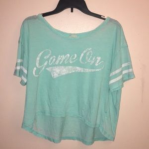 Teal tee with white writing and striped sleeves